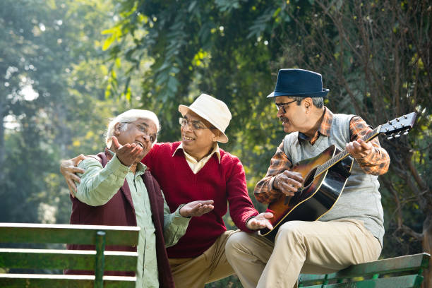 istock Three senior men playing guitar and having fun at park 1295223383