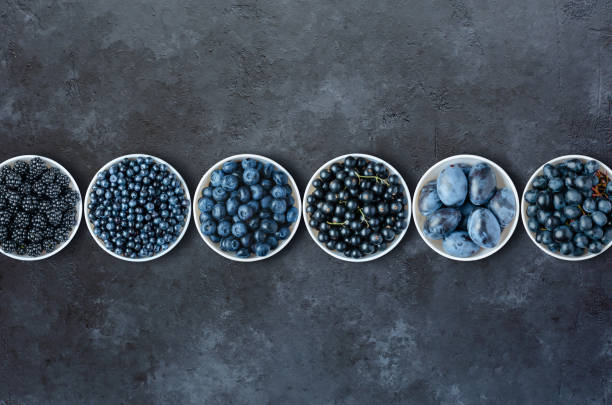 Berries in plates on a black concrete background. Copy space. Flat top view.