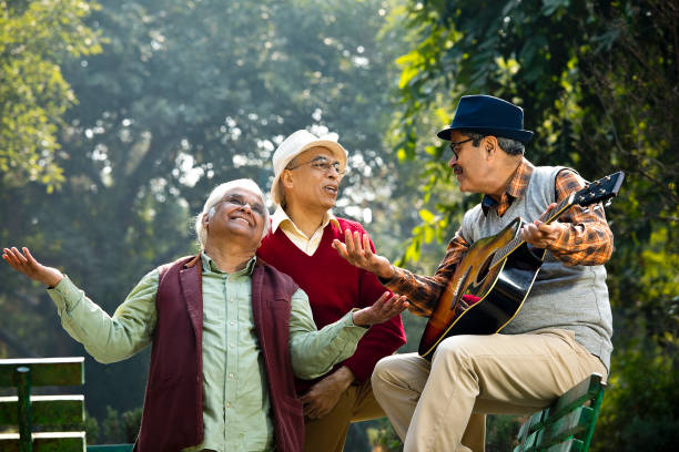 istock Three senior men playing guitar and having fun at park 1295224118