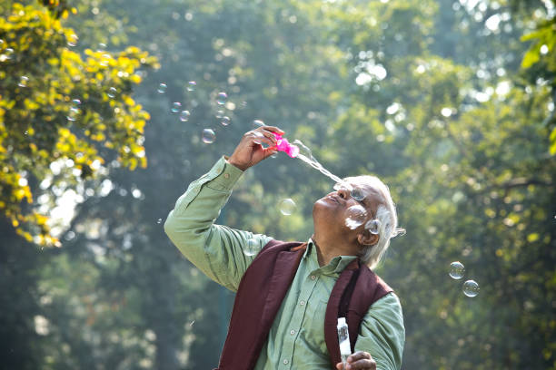 istock Senior men enjoying blowing bubbles at park 1295226065