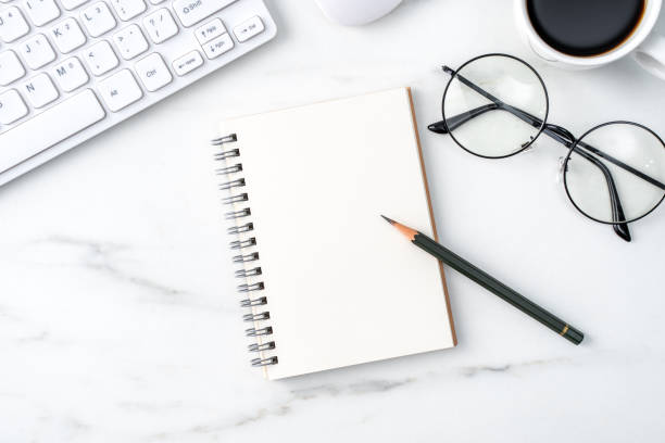 istock Top view of office table desk cozy work concept on bright marble white background. 1295226240
