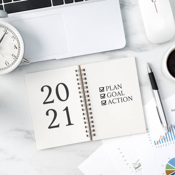 istock Top view of office table desk 2021 Goal work concept on bright marble white background. 1295226308