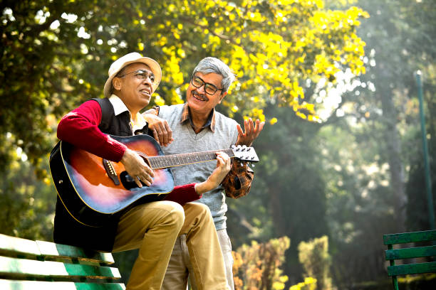 istock Two senior men playing guitar and having fun at park 1295226453