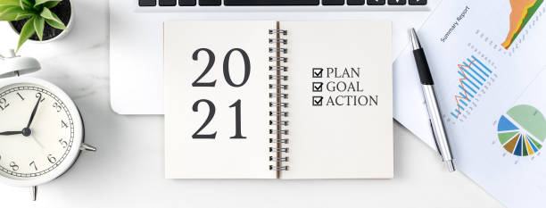 istock Top view of office table desk 2021 Goal work concept on bright marble white background. 1295226525