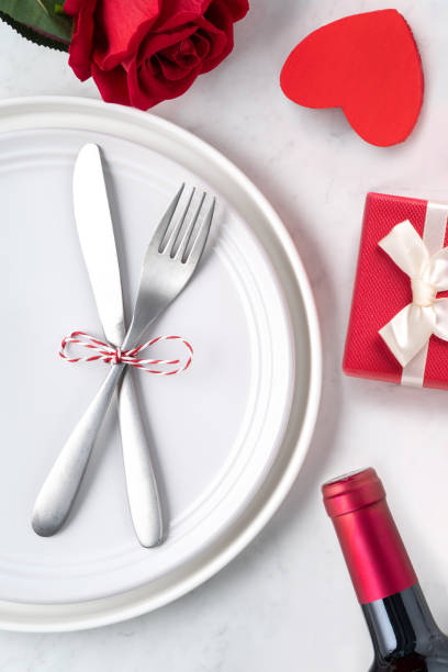 istock Plate with tableware, ribbon, gift and roses for Valentine's Day special meal concept. 1295226889
