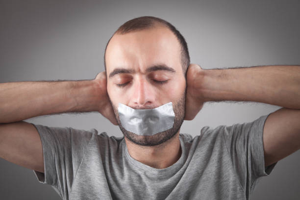 istock Caucasian man with tape on mouth. Censorship 1295226895