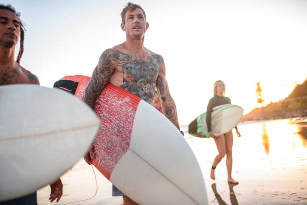 istock Early Morning Gold Coast Surfers Walking on Beach 1295227194