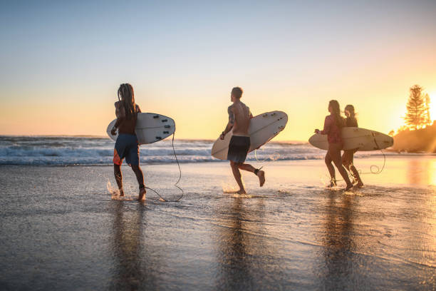 istock Gold Coast Surfers Running with Boards at Water’s Edge 1295227210