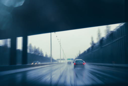 Drivers POV image taken from inside of a car driving in extreme weather conditions on highway with cars ahead. Blurred motion shot captured on highway (Lyngbyvej) in Copenhagen, Denmark.