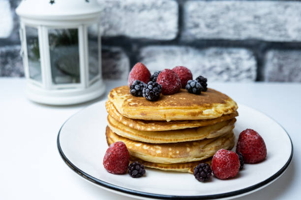 istock A stack of blackberry and strawberry pancakes on a plate. 1295232311