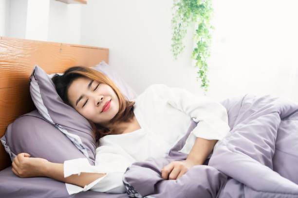 istock Asian woman peacefully sleeping well on comfortable soft bed 1295232812
