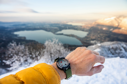 Hand of hiker with compass watch seeks direction