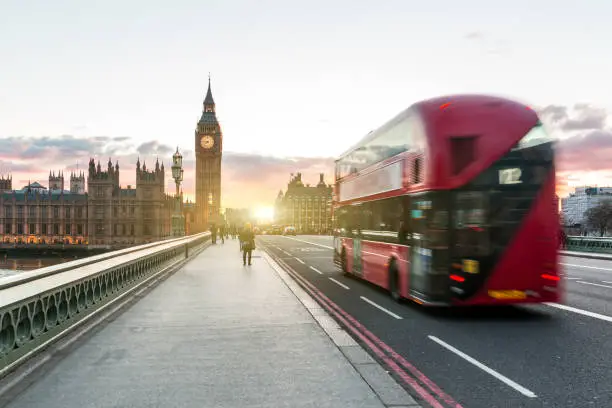 Red double decker bus and Big Ben in London at sunset