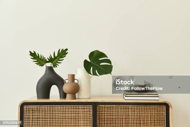 Modern Scandinavian Home Interior With Design Wooden Commode Tropical Leaf In Vase Books And Personal Accessories In Stylish Home Decor Template Copy Space White Walls Stock Photo - Download Image Now