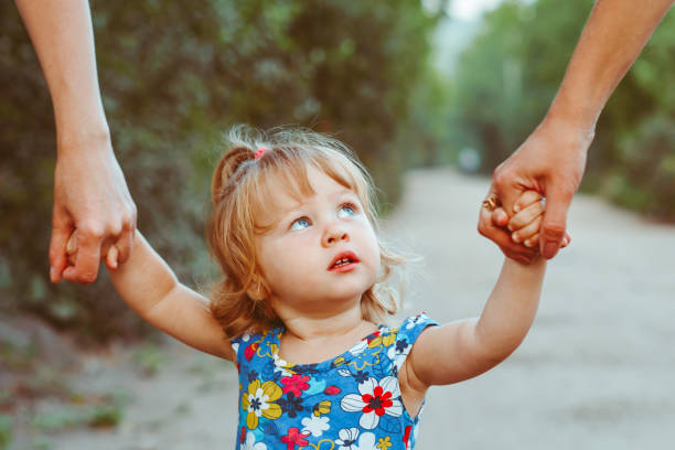 istock parents walk with a child holding hands 1295250834