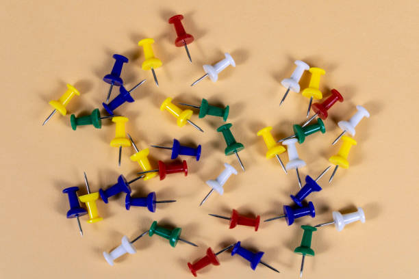 istock Multicolored push pins on the light background. Close up. Selective focus. 1295252420