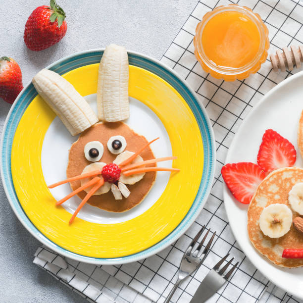 Creative breakfast for kids on Easter Creative breakfast for kids on Easter. Bunny shaped sweet pancake with fruits, berries and honey. Baby food bunny pancake stock pictures, royalty-free photos & images