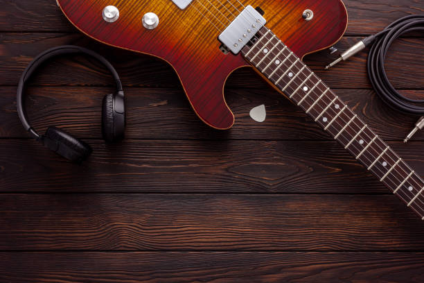 Beautiful electric guitar on with headphones and coffee desktop