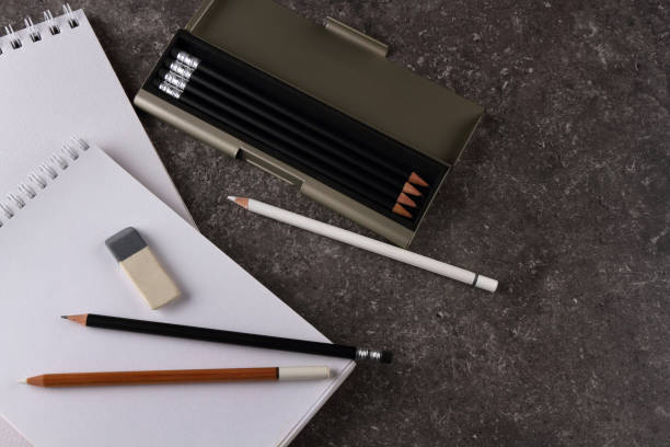istock Drawing pad and pencils on a granite texture for table 1295262431