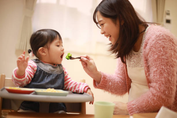 親子食べる - baby eating child mother ストックフォトと画像