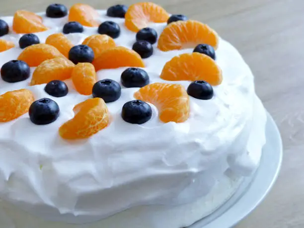A very fresh and juicy-looking and inviting cream cake with blueberries and mandarins