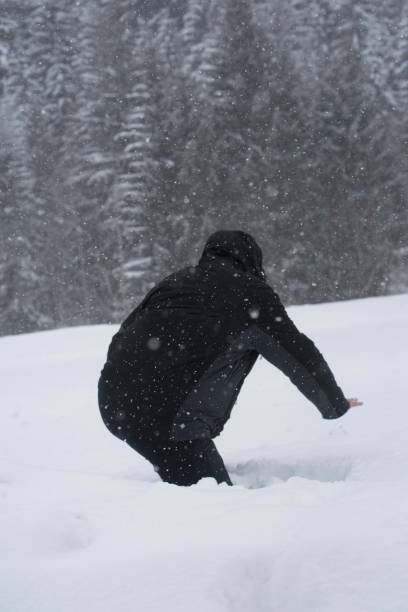 istock person in black clothing walking in deep snow 1295270492