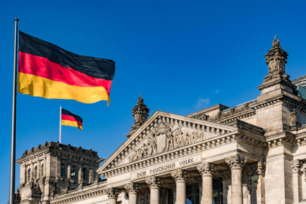 The federal flag in front of the impressive Reichstag in Berlin as a symbol of democracy The german Reichstag with a dedication to the people in the German capital Berlin german flag stock pictures, royalty-free photos & images