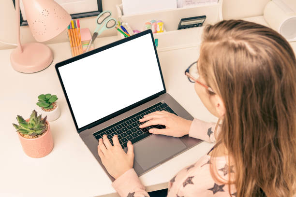 istock Education - girl child using the laptop computer. Blank screen - copy space. 1295275044