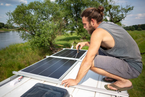istock Man on top of a camper van next to solar panels 1295282039