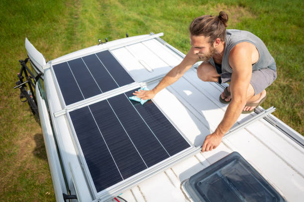 istock Man cleaning a solar panel on the roof of a camper van 1295282092