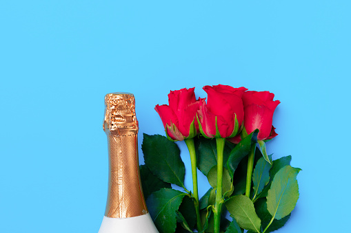 Bouquet of roses and champagne top view flat lay