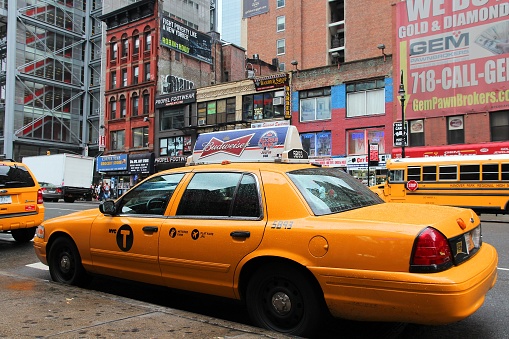 People ride yellow cabs in Midtown Manhattan in New York. As of 2012 there were 13,237 yellow taxi cabs registered in New York City.