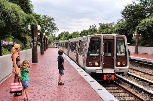 People wait for Metro train at Arlington Cemetery station in Washington. With 212 million annual rides in 2012 Washington Metro is the 3rd busiest rapid transit system in the USA.