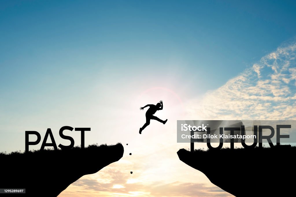 Go ahead and continuously improvement concept, silhouette man jump on a cliff from past to future with cloud sky background. The Way Forward Stock Photo