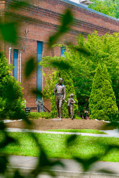 "Andy and Opie" Statue at the Andy Griffith Playhouse, Mount Airy, NC Mount Airy, North Carolina / USA - July 5, 2020: The "Andy and Opie Taylor” statue by sculptor Stuart Williamson is a popular tourists stop at the historic “Andy Griffith Playhouse” that honors the town’s most famous citizen. griffith andy stock pictures, royalty-free photos & images