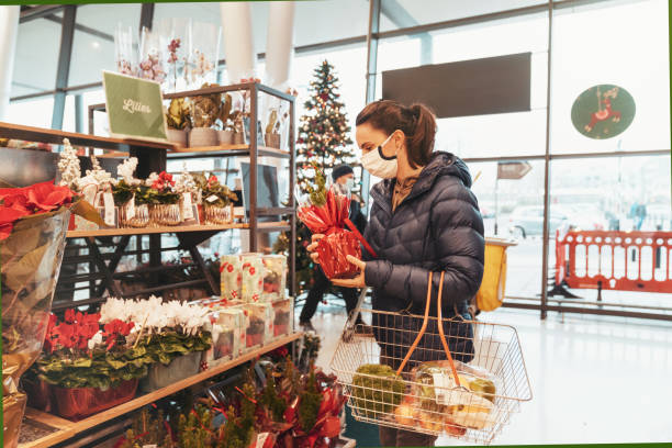 young woman shopping for healthy food in supermarket with protective facemask - woman reaching into handbag imagens e fotografias de stock