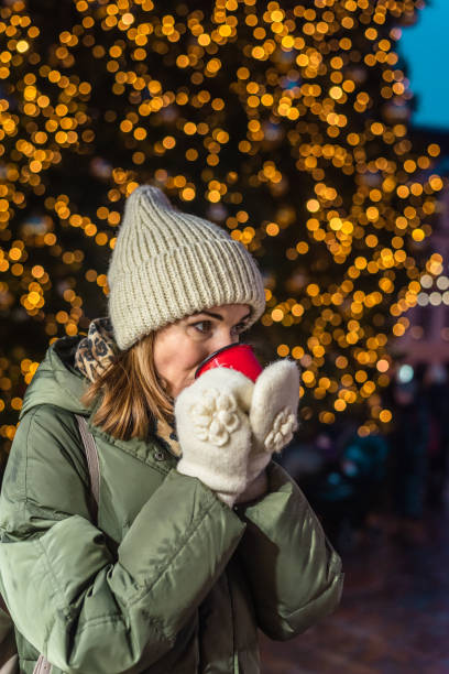 istock Woman drinking on Christmas market 1295290870