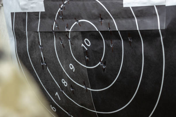 istock Shot up target with bulls-eye, holes from bullets 1295292199