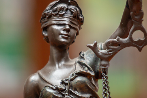 Blindfold on the eyes of Themis, a symbol of impartiality. Justice, court, human rights, advocacy, lawyering and education concept