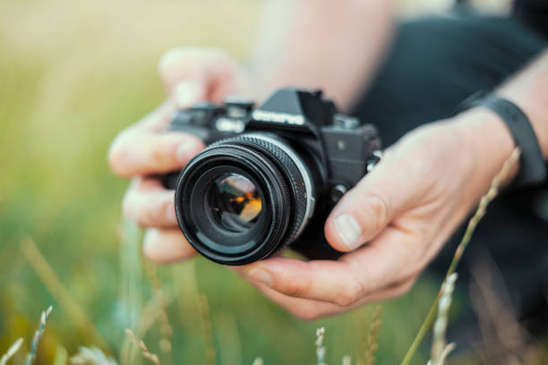 istock Man holding mirror les camera in the nature 1295293437