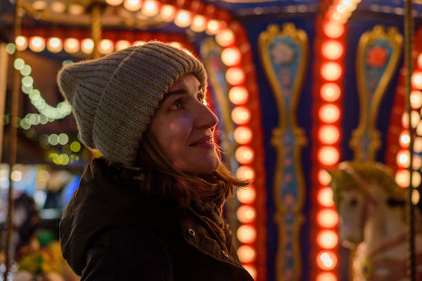 istock Smiling woman near christmas carousel 1295293675