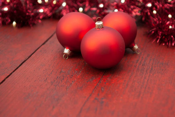 A red Christmas ball lies on a red background.