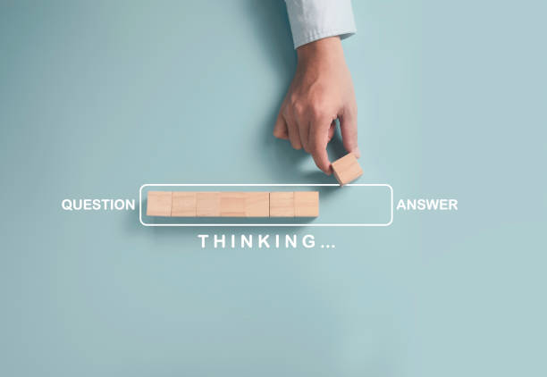 istock Businessman putting wooden cube block for update progressive between questions and answer on blue background. 1295294827