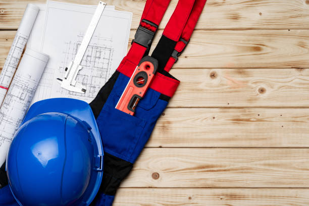 istock Construction worker unifrom, hardhat and blueprints on wooden background 1295296276