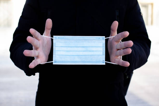 istock A man holds a medical mask in the cold 1295306088