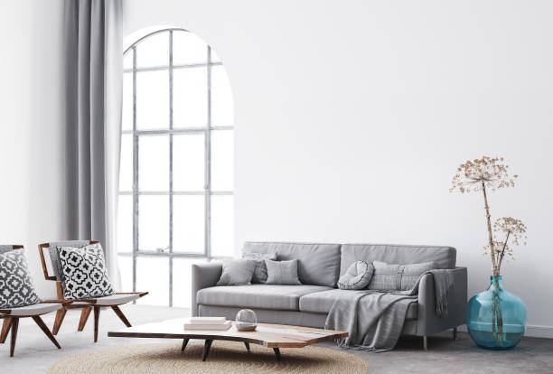 istock interior living room design with simple white background mock up. Modern grey sofa with cushions and plaid , blue vase, dried flowers and natural wooden 1295306257
