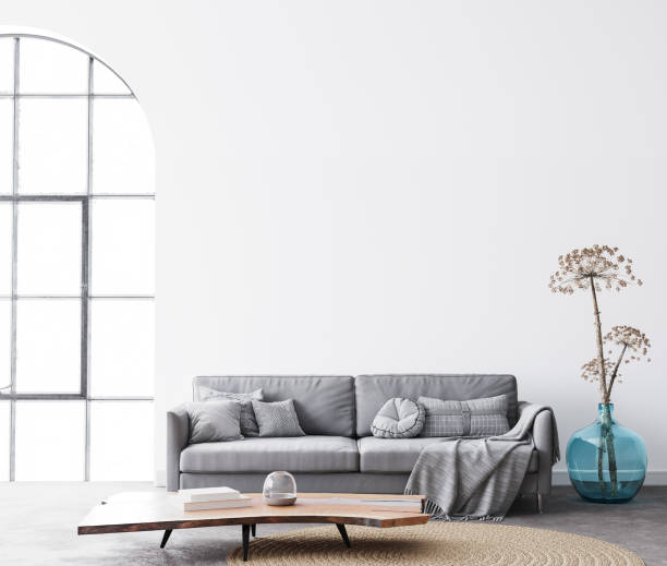 istock interior living room design with simple white background mock up. Modern grey sofa with cushions and plaid on 1295306285