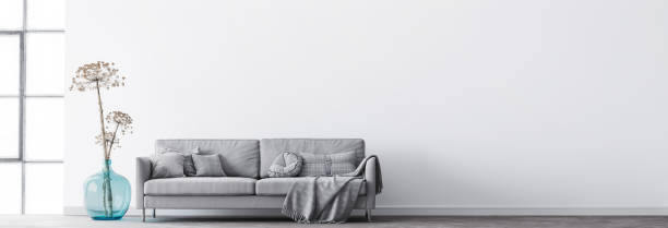 istock Minimal interior living room design, modern grey sofa with cushions plaid on empty white background with big window, blue vase, and trendy dried flowers. 1295306292