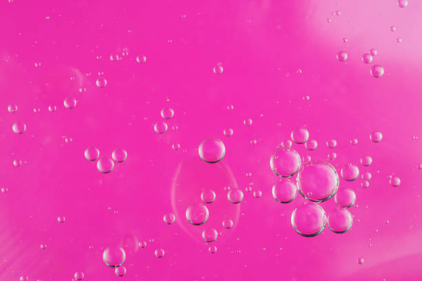 istock oil drops on water on a pink background 1295307427