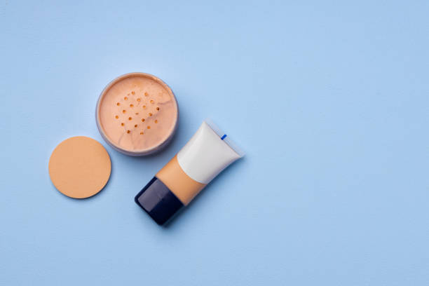 istock Complexion make up products and brush on blue background 1295308004